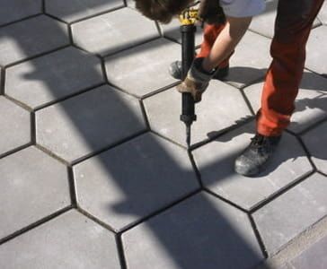 An employee in work clothes works on joints on a floor